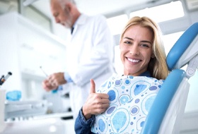 woman giving thumbs up while attending dental checkup and cleaning in Corbin