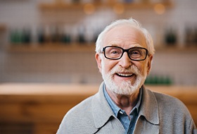 Senior man with glasses sitting and smiling