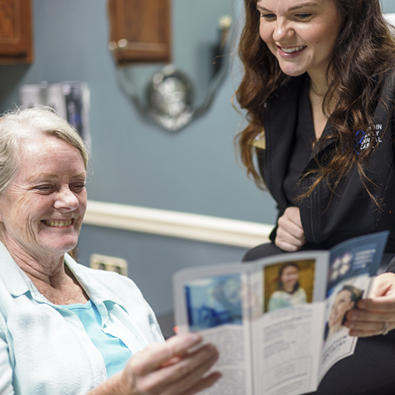 Dental team member showing a pamphlet to a patient