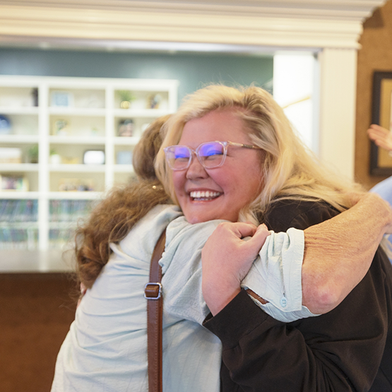 Two women hugging in the dental office