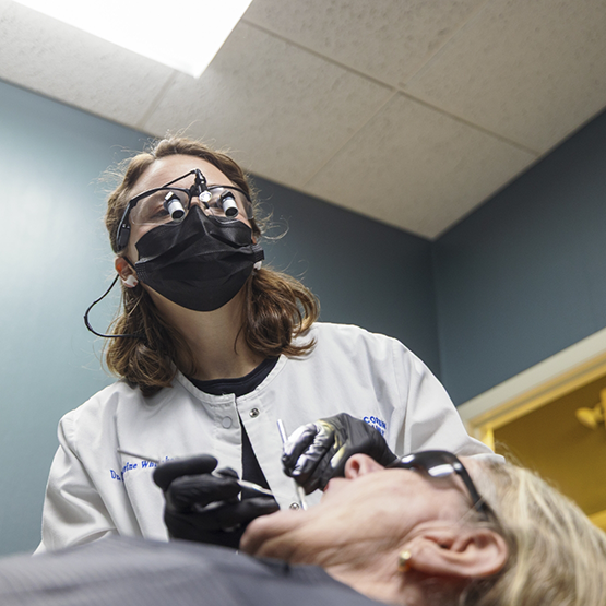 Doctor Whitaker examining a patient's teeth