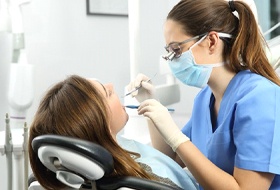 dental hygienist cleaning a patient’s teeth