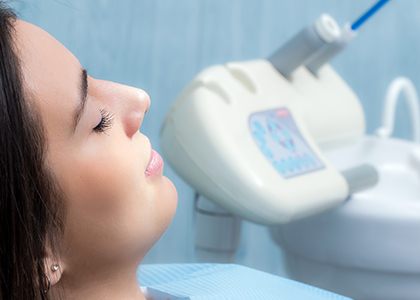 Woman in dental chair with eyes closed