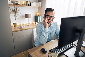 man smiling while talking on the phone