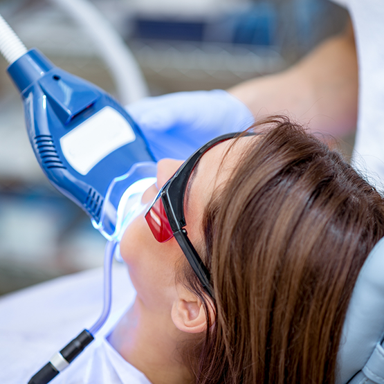 Woman in the dental chair getting her teeth whitened