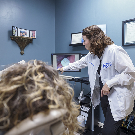 Cosmetic dentist showing a patient a photo of their tooth