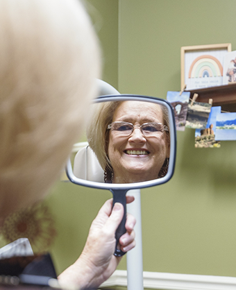 Dental patient looking at her smile in a mirror