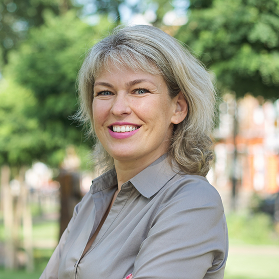 Woman in a gray blouse smiling outdoors