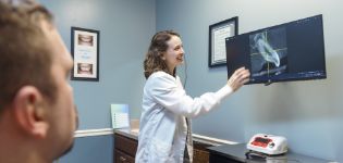 Doctor Whitaker showing a patient an x-ray of their teeth