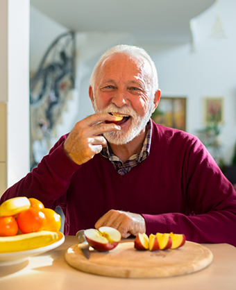 Senior man eating apple slices