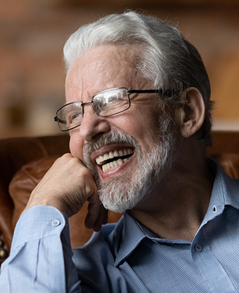 Smiling with a gray beard and hair