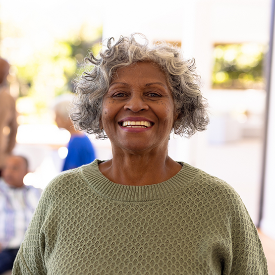 Older woman smiling in a light brown sweater