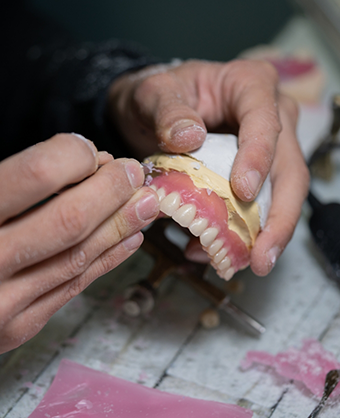 Dental lab worker adjusting a denture