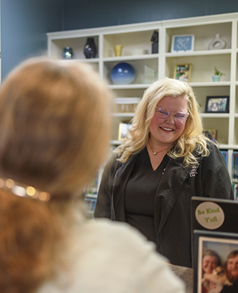 Dental team member smiling at a patient at the front desk