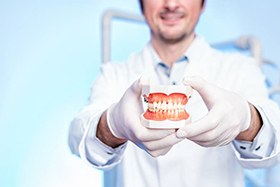 Dentist holding model denture