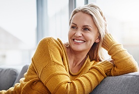 a woman smiling with dentures and walking with friends