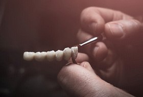 Lab technician painting replacement teeth