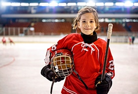 a young hockey player smiling in the rink