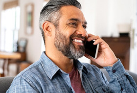 man smiling while talking on phone
