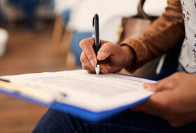 woman filling out dnetal insurance form in lobby