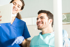 dentist showing patient image on tablet