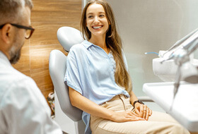 female patient smiling at dentist at dental appointment