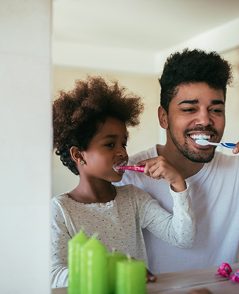 Father and daughter brushing their teeth