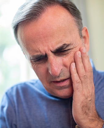 Man holding the side of his face in pain