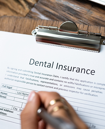 Person filling out dental insurance paperwork