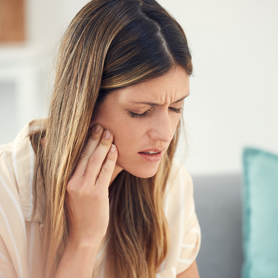 Woman holding her cheek in pain