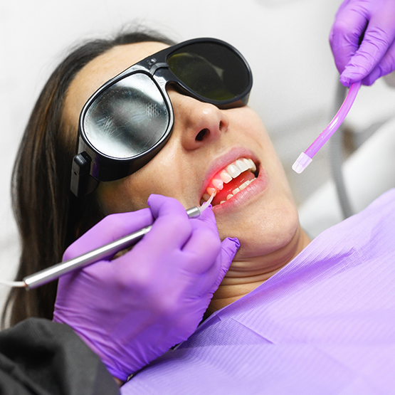 Woman getting gum disease treatment with a laser