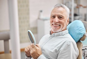 Smiling senior man happy he could afford dental implant treatment