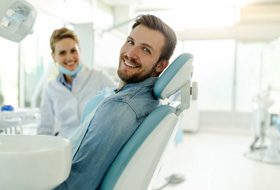 Man smiling while sitting in treatment chair