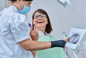 Patient smiling at dentist while reviewing X-ray