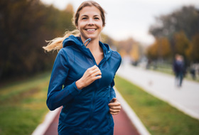 Woman smiling while jogging at park