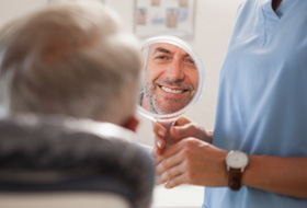 Man smiling at reflection in small mirror