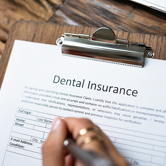 Person filling out dental insurance paperwork