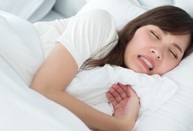 Sleeping woman clenching teeth