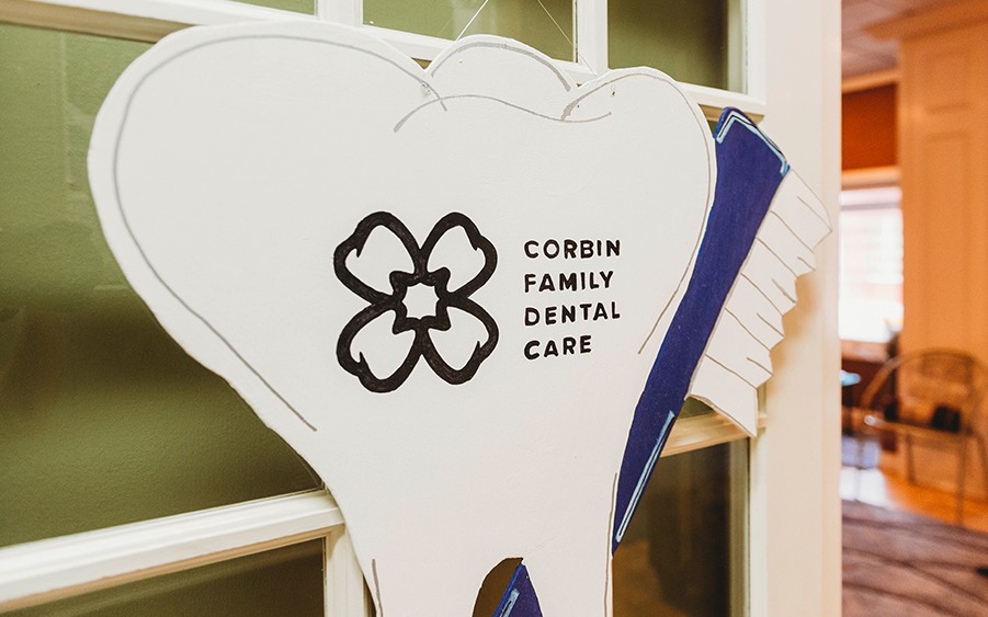 corbin family dental care tooth sign on door