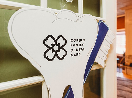 corbin family dental care tooth sign on door