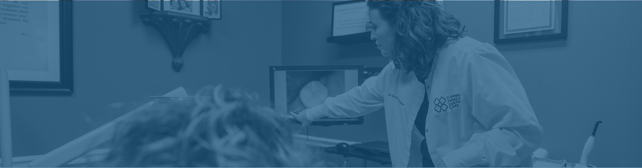 Doctor Whitaker showing a patient a photo of their tooth