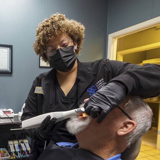 Dental team member taking scans of a patient's mouth