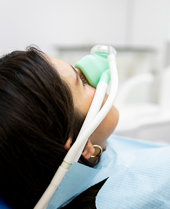 Dental patient with a nitrous oxide mask over her nose