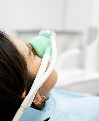 Dental patient with a nitrous oxide mask over her nose