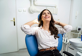 Woman in white shirt smiling in treatment chair