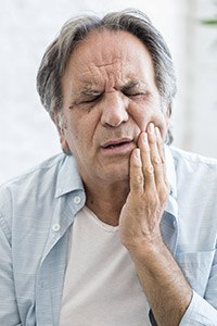 Man holding jaw in pain