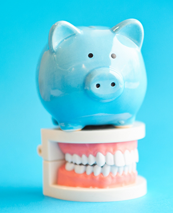 Piggy bank sitting on a model of the teeth