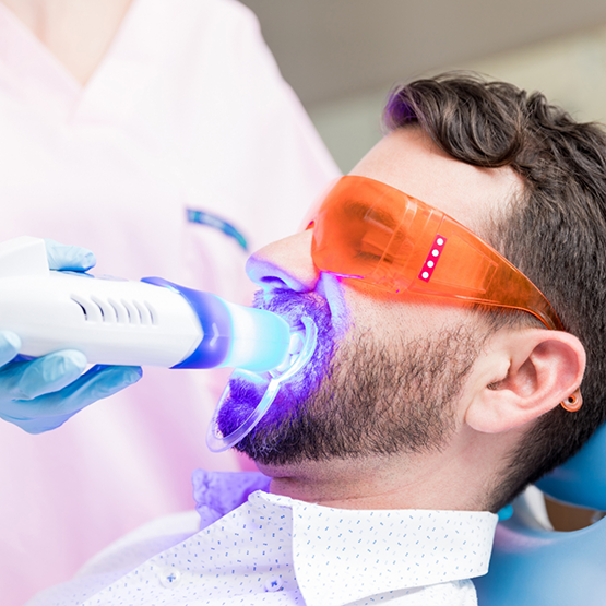 Man in the dental chair getting professional teeth whitening
