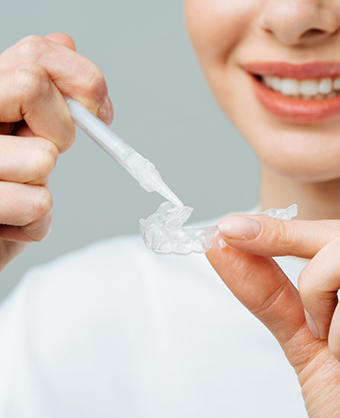 Woman using a teeth whitening kit