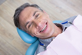 Man lying back in dental chair and smiling